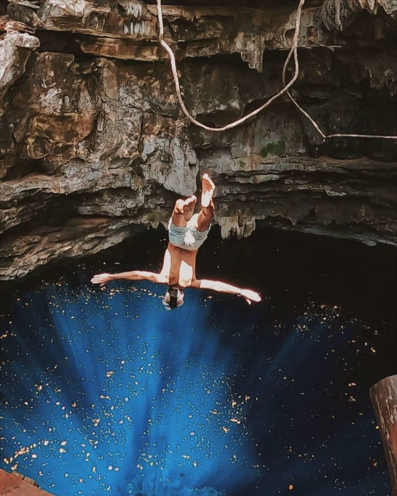 Salto controlado hacia el agua cristalina de un cenote